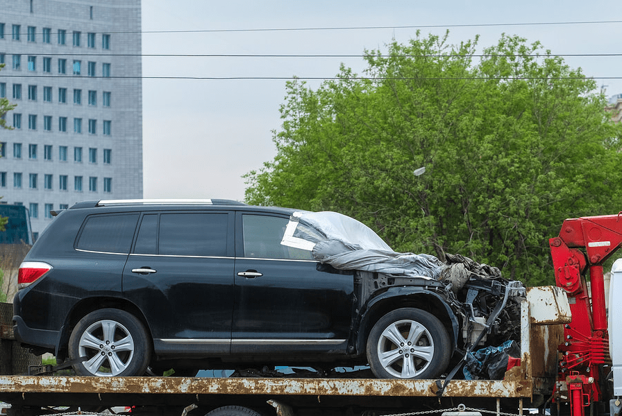 a black crashed car on the towing truck